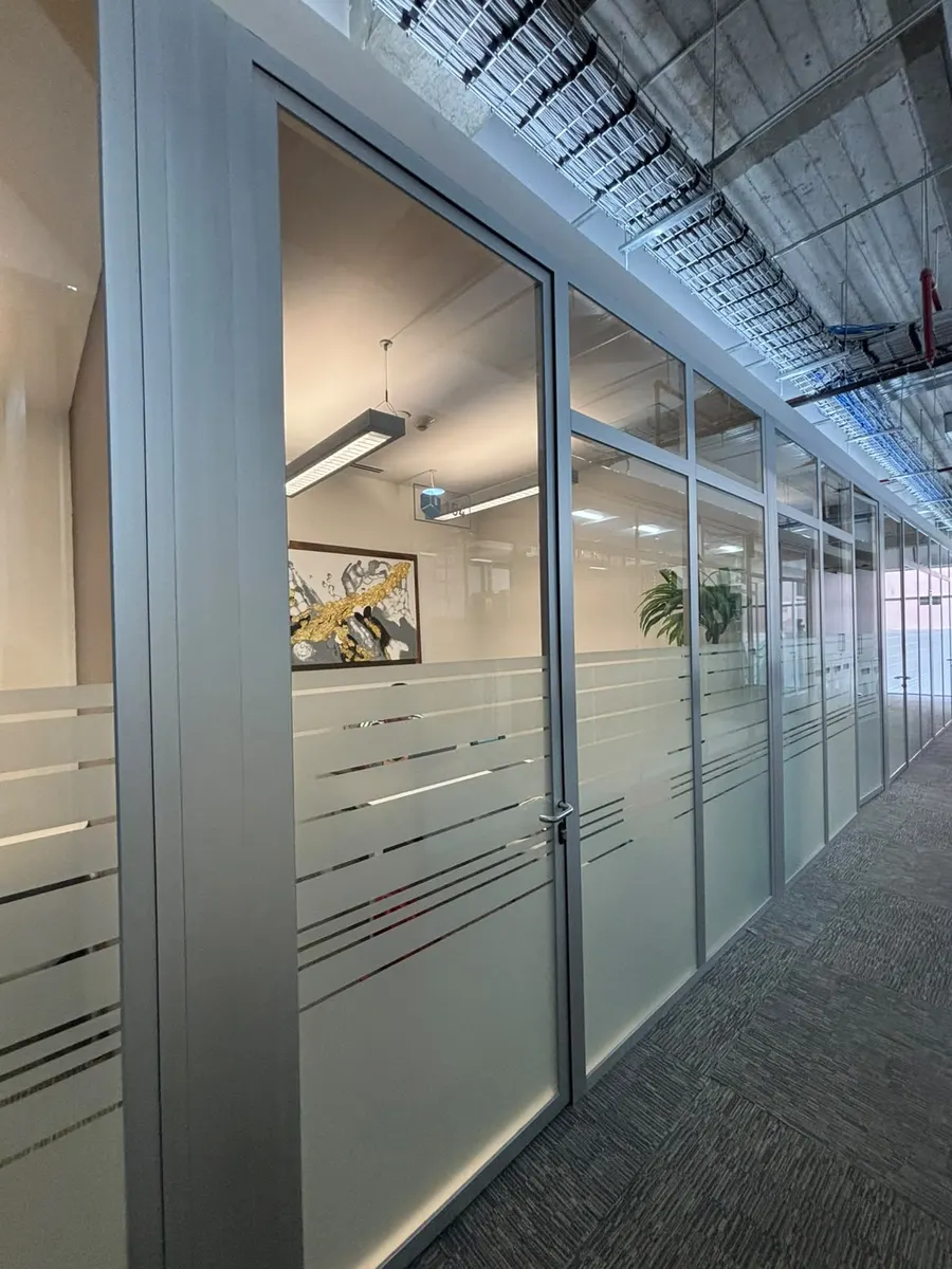 Pasillo con salas de juntas de vidrio esmerilado en la oficina de RJ Staffing Solutions en Guadalajara